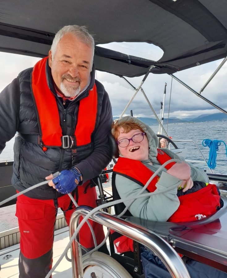 Steve, an able2sail volunteer and Mia a young sailor laughing